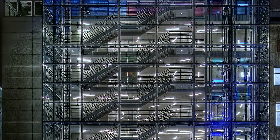 Nachtansicht der beleuchteten Volkshochschule, Glasbau